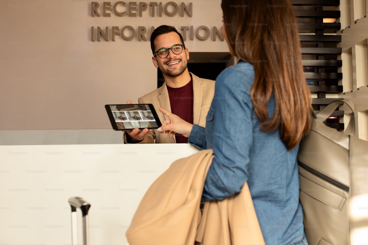 A hotel front desk team working at a modern reception — the operational heart that a property management system either empowers or constrains